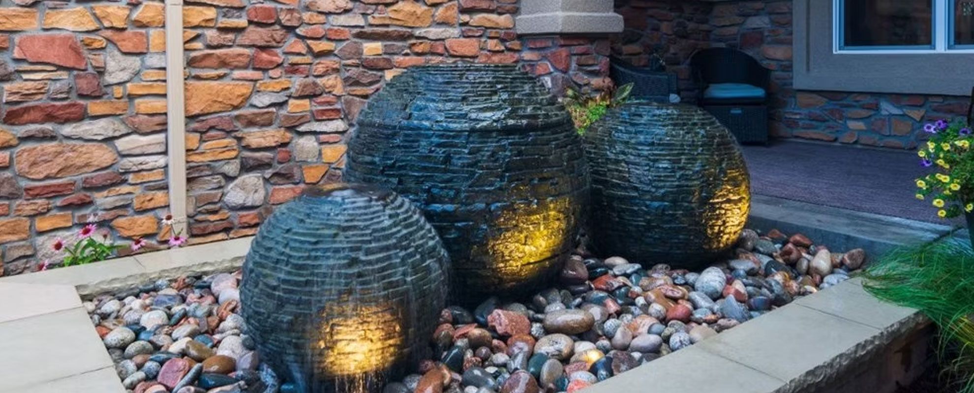 Three slate sphere fountains lit at dusk